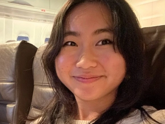 Person with white shirt and brown hair smiling