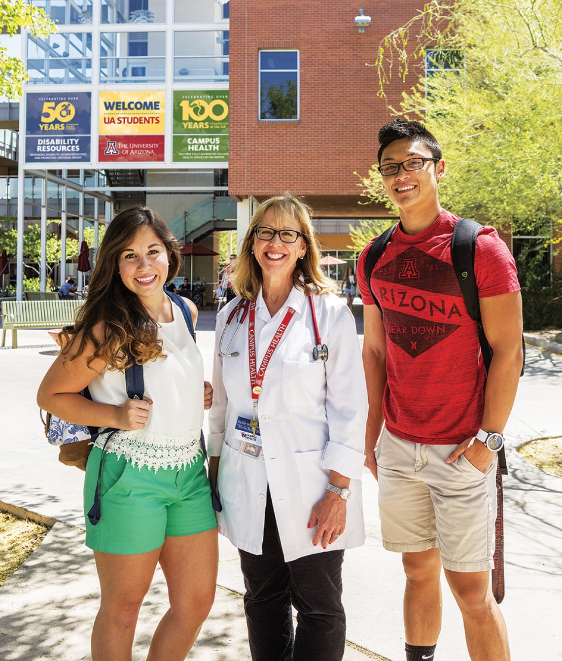 Doctor and two students in front of Campus Health