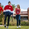 3 students walking and talking in front of old main